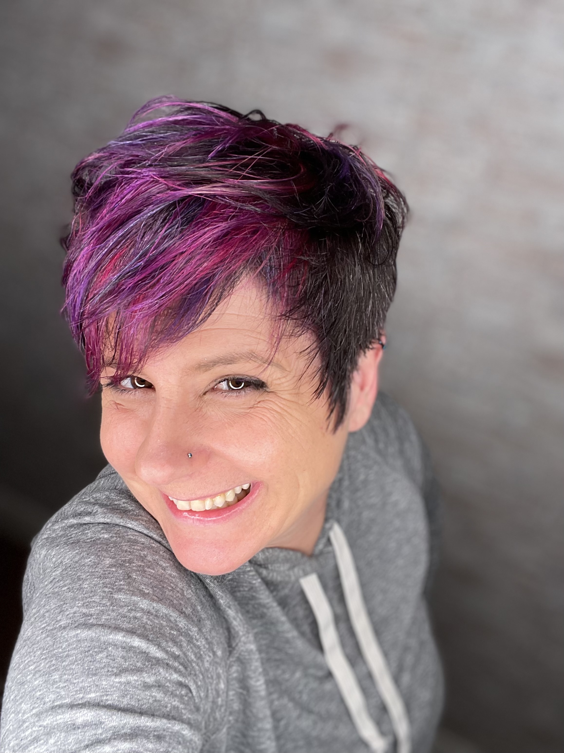 Jessica, owner of HairPixie Salon, with a vivid purple pixie cut